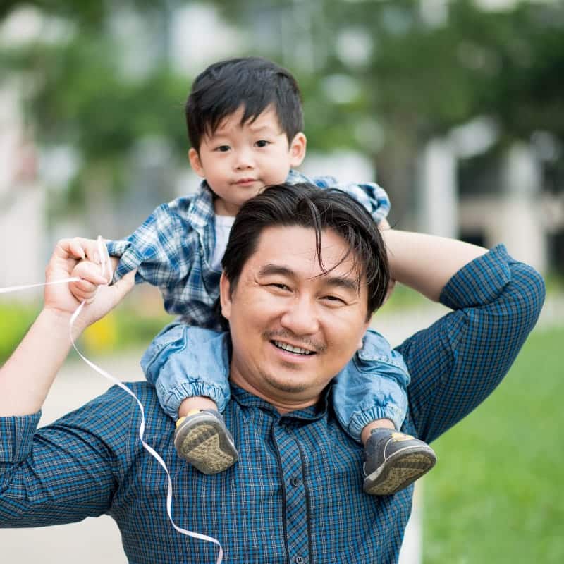 Father carrying toddler on his shoulders